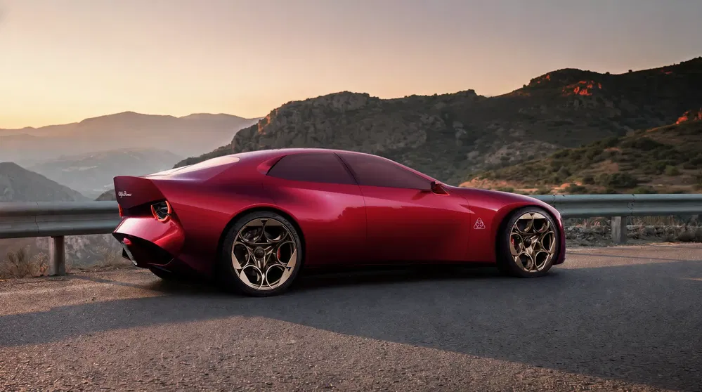 Voiture concept Alfa Romeo en métal rouge au coucher du soleil sur route de montagne.