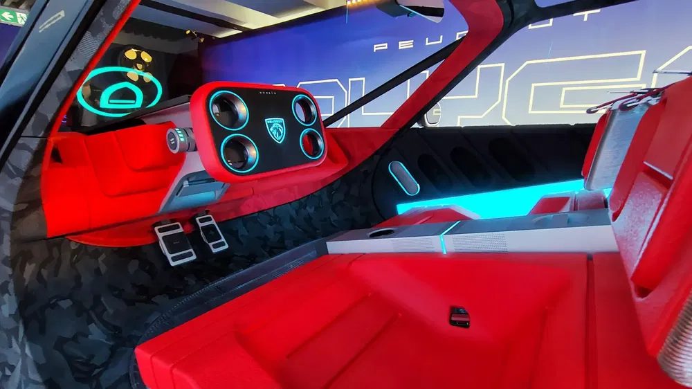 Intérieur futuriste de concept-car Peugeot Inception avec tableau de bord numérique et sièges rouges.