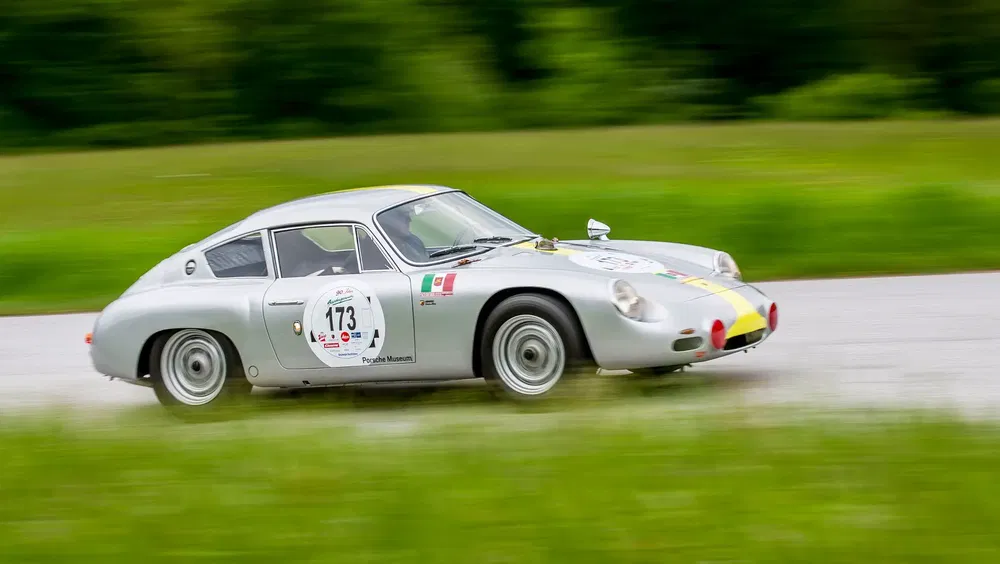 Porsche 356 Abarth Carrera GTL de course sur piste, arrière-plan flou vert.