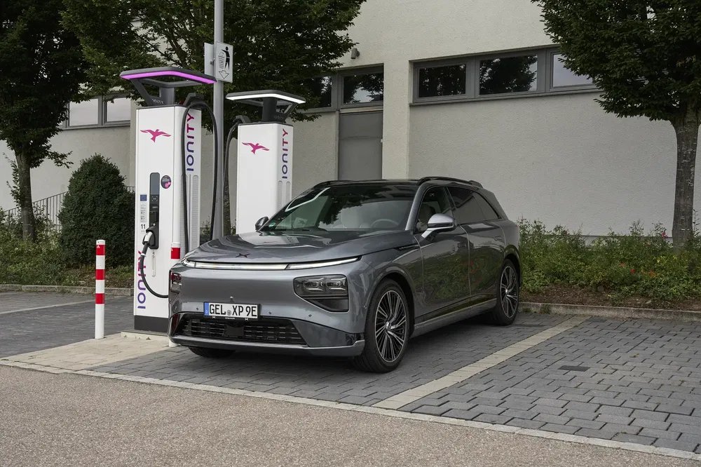 XPeng elektrische auto laadt op bij een moderne Ionity-station met witte laadpalen.