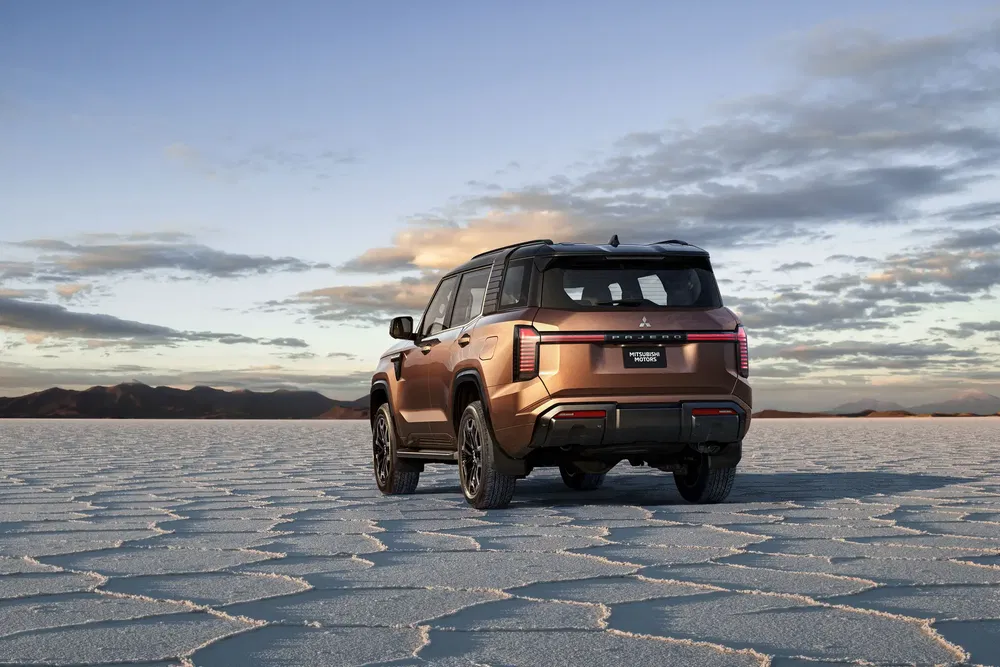SUV Mitsubishi sur un lac salé au crépuscule, paysage vaste et spectaculaire.