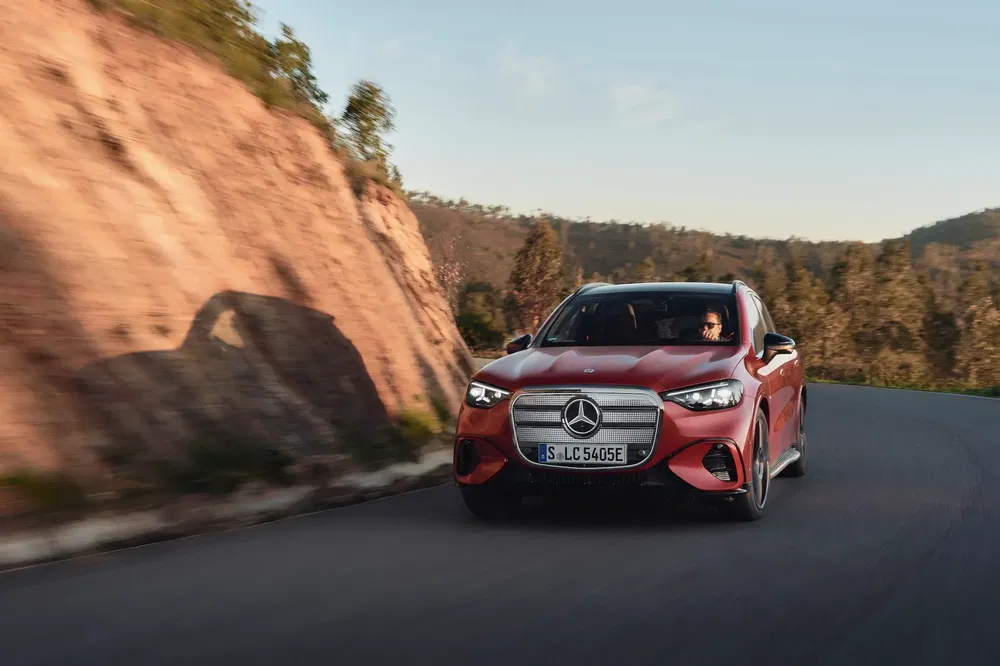 {"fr":"Mercedes-Benz rouge roulant sur une route sinueuse entourée de paysages montagneux.","nl":"Rode Mercedes-Benz rijdt op bochtige weg omringd door berglandschap."}