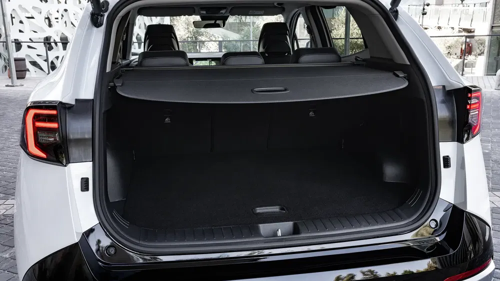 Coffre d'un SUV Peugeot 5008 moderne avec cache-bagages rétracté et sièges arrière en vue.