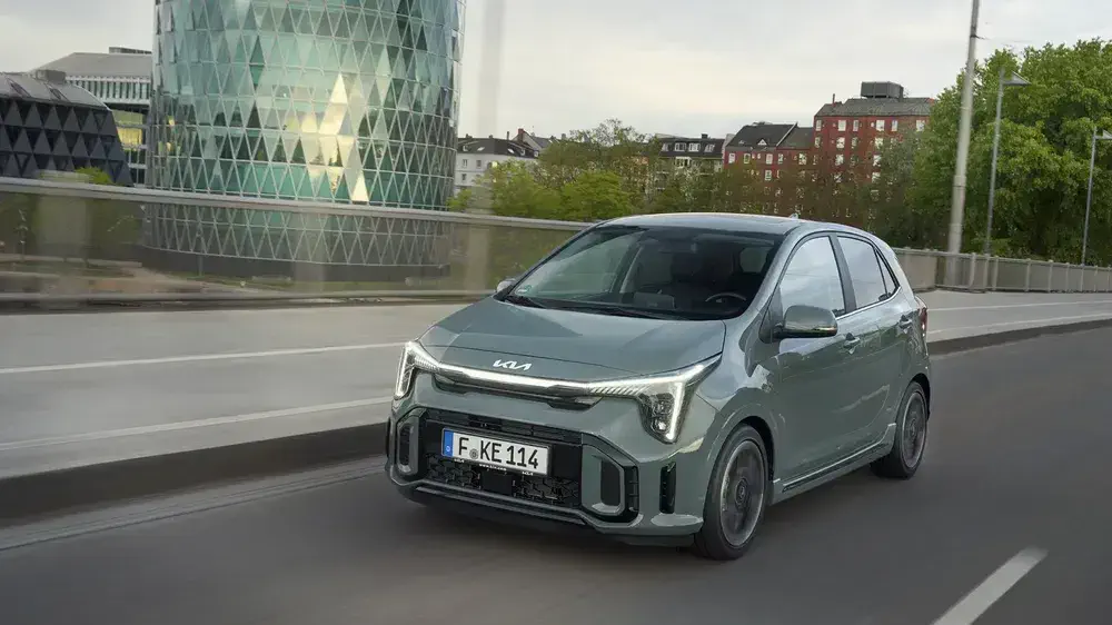 {"fr":"Kia Picanto 2023 gris roulant sur un pont urbain, bâtiment moderne en arrière-plan.","nl":"Grijze Kia Picanto 2023 rijdt op stadse brug met modern gebouw op de achtergrond."}