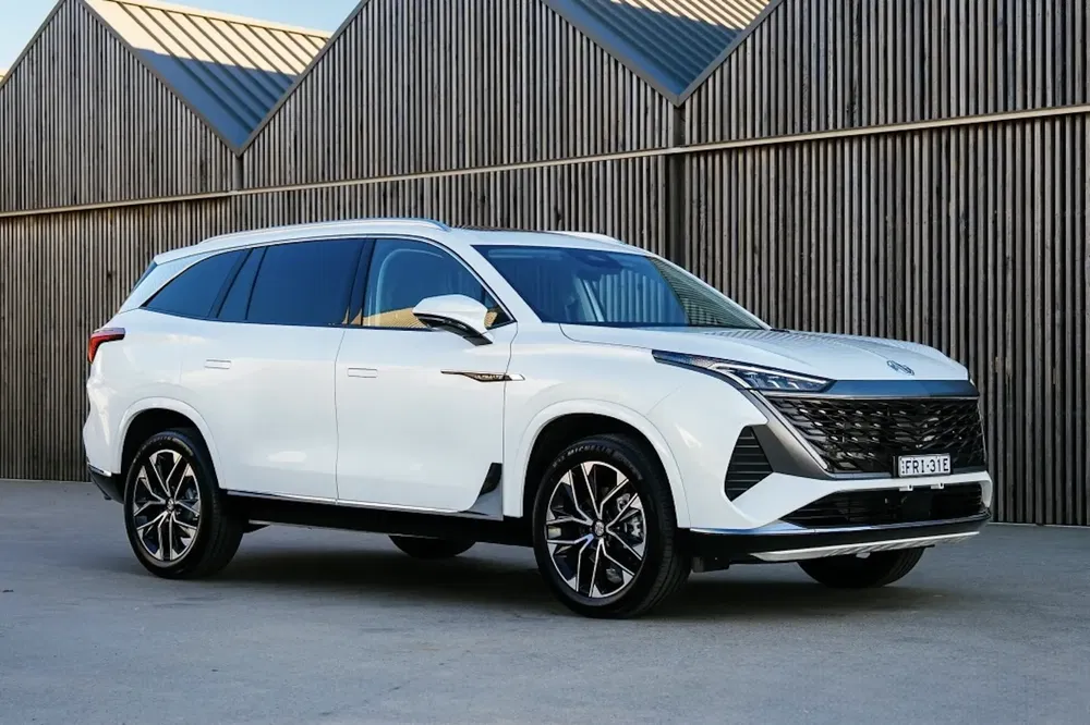 Witte moderne SUV voor houten gebouw, ontworpen voor efficiëntie en stedelijke stijl.