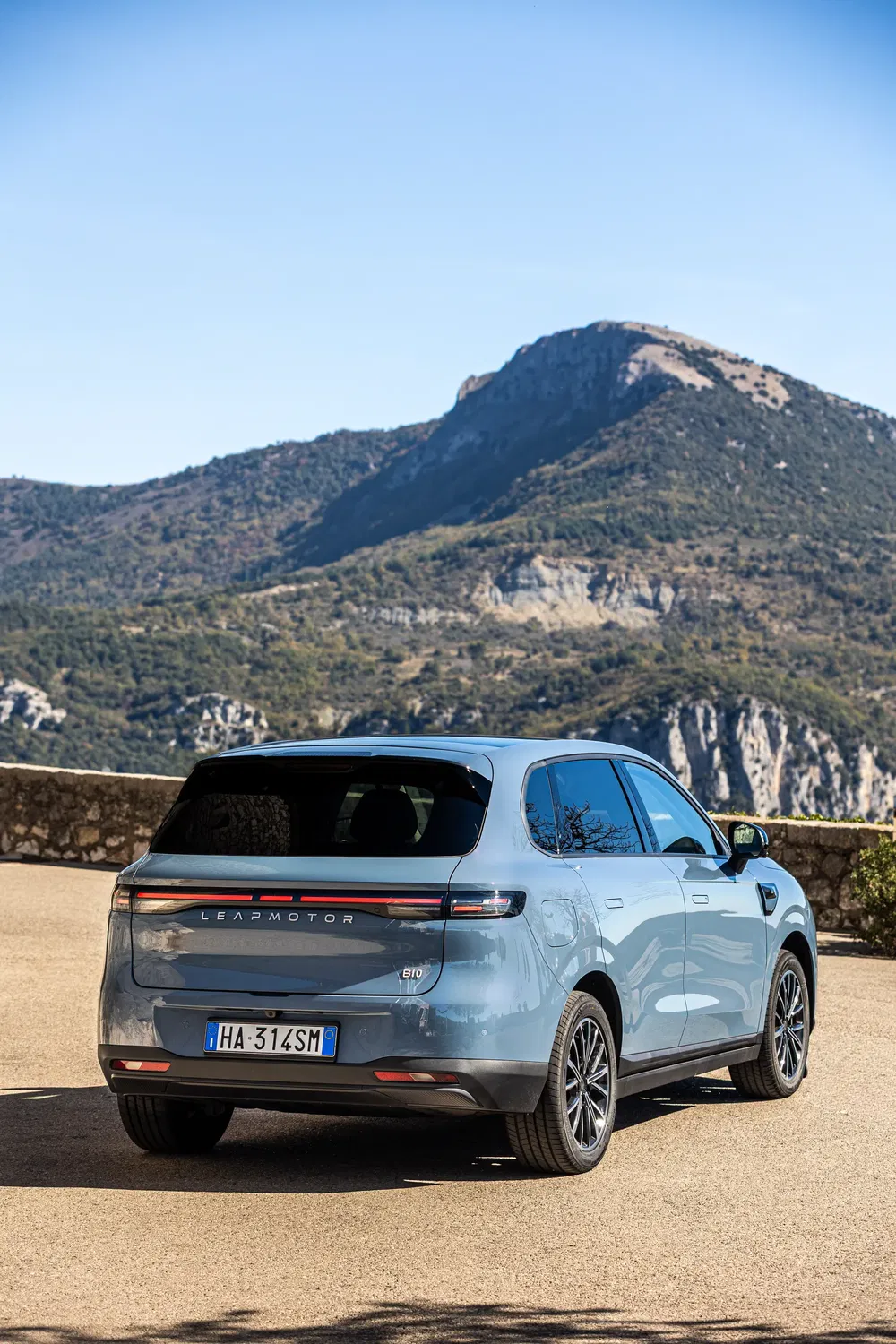 SUV Leapmotor C10 bleu garé devant un paysage de montagne.