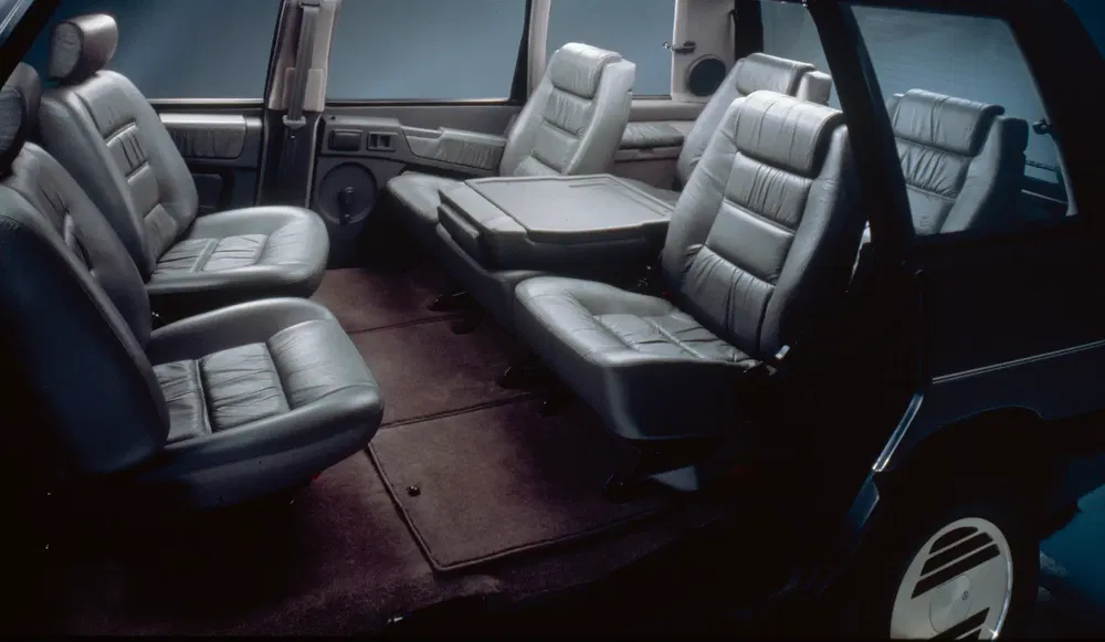 Intérieur spacieux d'une Renault Espace avec sièges en cuir et table centrale.