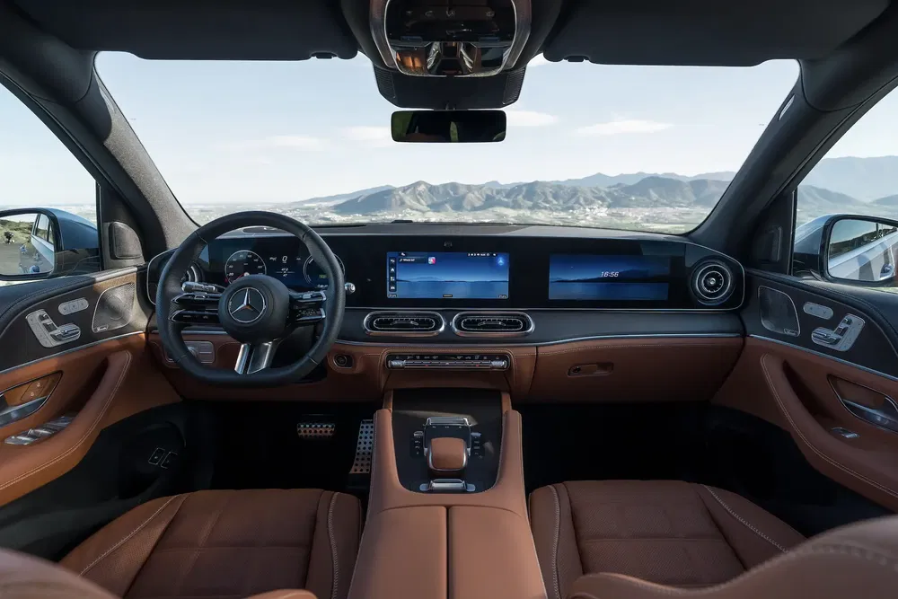 Intérieur luxueux d'une Mercedes, écran large et volant élégant avec vue panoramique.