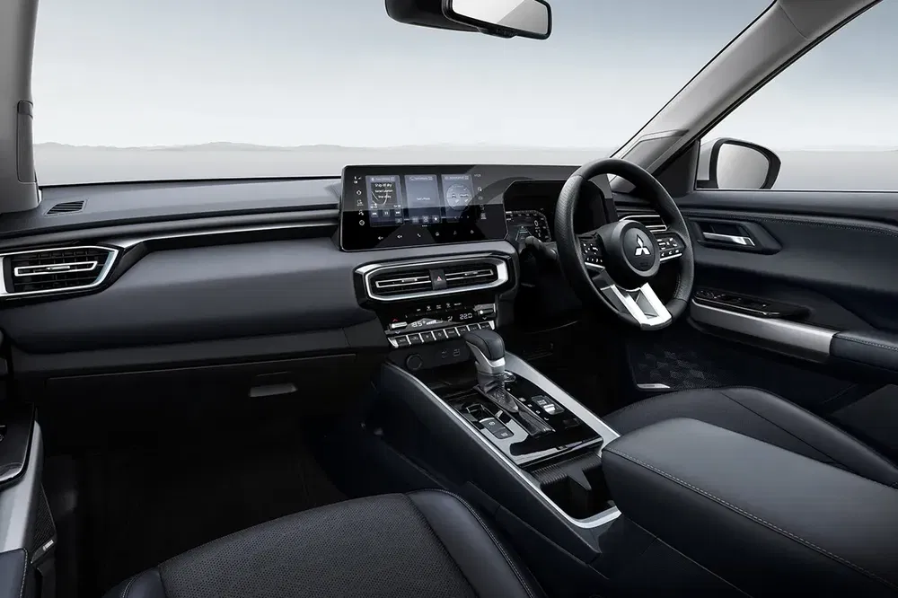Intérieur moderne Mitsubishi avec écran tactile et volant multifonction, finition élégante.