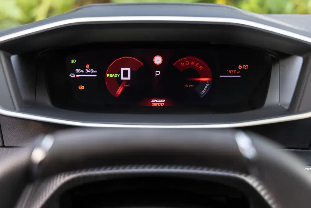 Tableau de bord numérique de la Peugeot 208, affichant autonomie et puissance électrique.