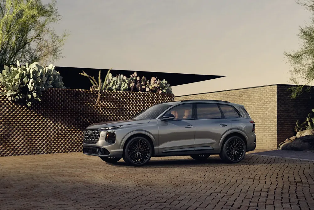 SUV moderne stationné devant une maison élégante avec un jardin désertique.