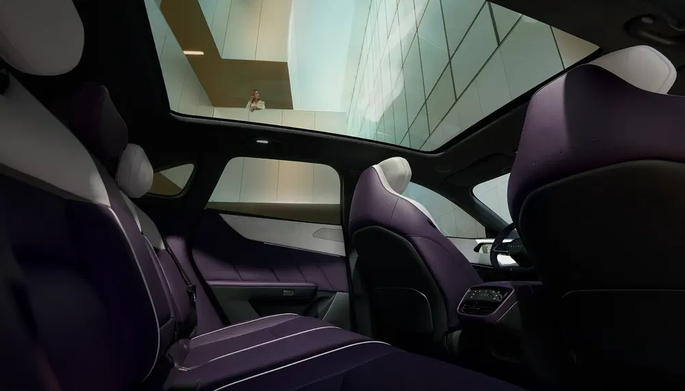 Intérieur luxueux d'une voiture avec toit panoramique et sièges en cuir violet moderne.