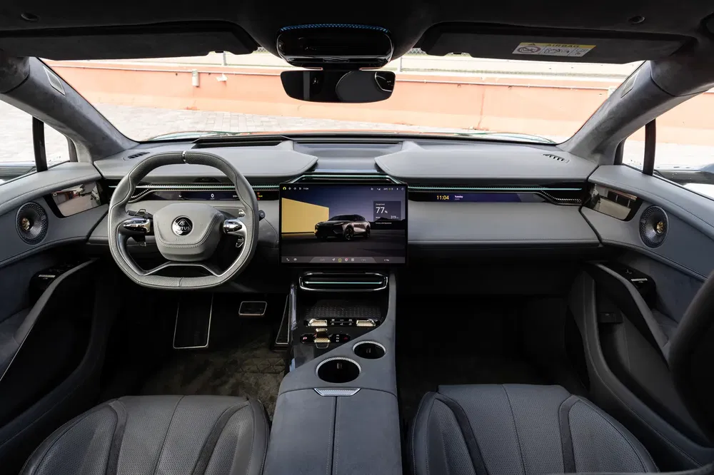 Moderne interieur van elektrische auto ZEEKR 001 met multifunctioneel stuur en centraal scherm.