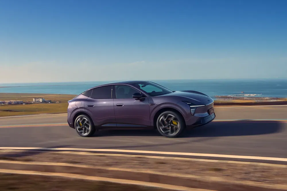 Sedan électrique XPeng G6 roulant sur une route côtière par temps ensoleillé.