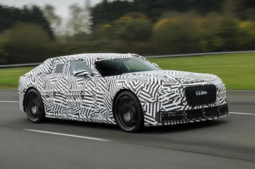 Geavanceerde prototype-auto met camouflagepatroon rijdt op de weg, futuristisch en gestroomlijnd ontwerp.