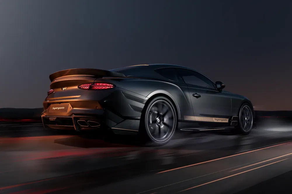Bentley Continental Supersports roulant sur route la nuit, illuminée par éclairage urbain.