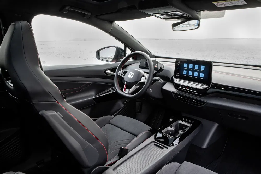 Interieur van een Volkswagen met centraal touchscreen en moderne grijze stoffen stoelen.