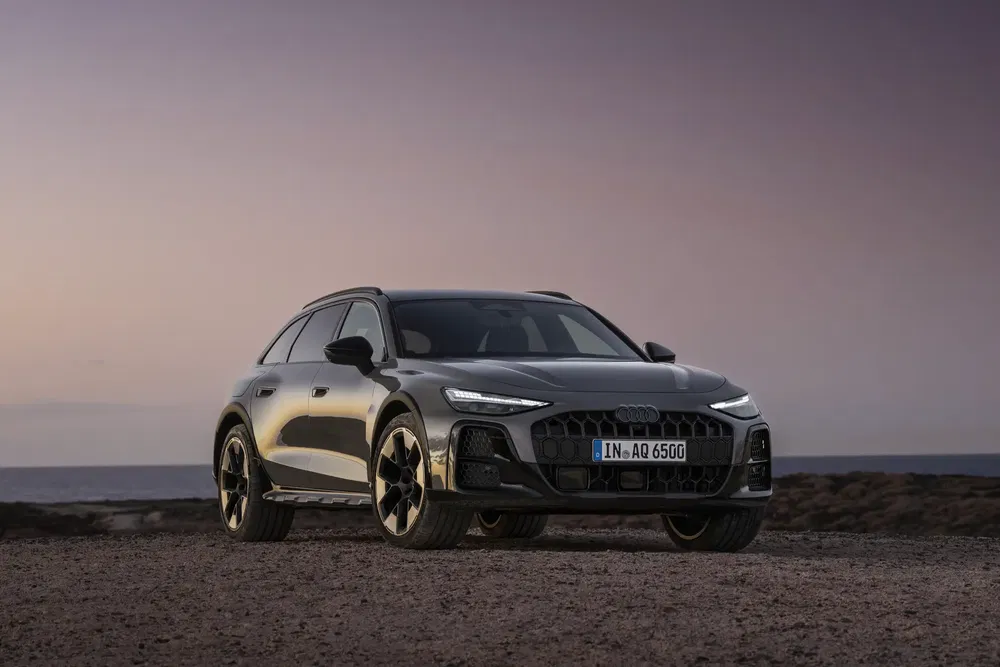 Audi A6 Avant e-tron op kustweg bij schemering, gestroomlijnd en modern design.
