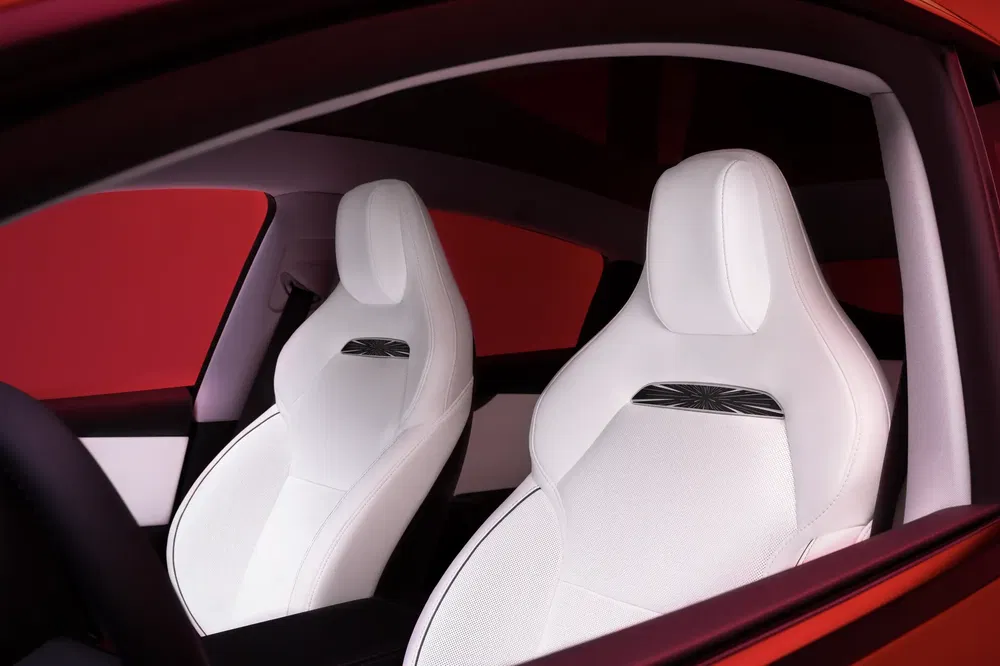 Moderne interieur van rode auto met elegante, minimalistische witte leren voorstoelen.