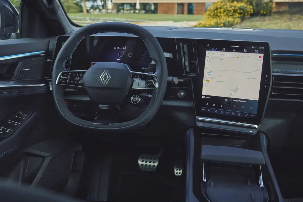 Intérieur de voiture Renault avec volant moderne et écran tactile affichant la navigation.