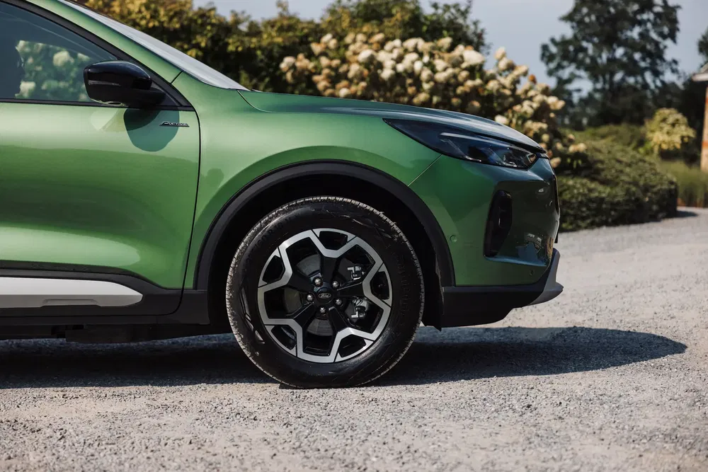 BYD Atto 3 vert sur chemin, accent sur roue et carrosserie élégante.