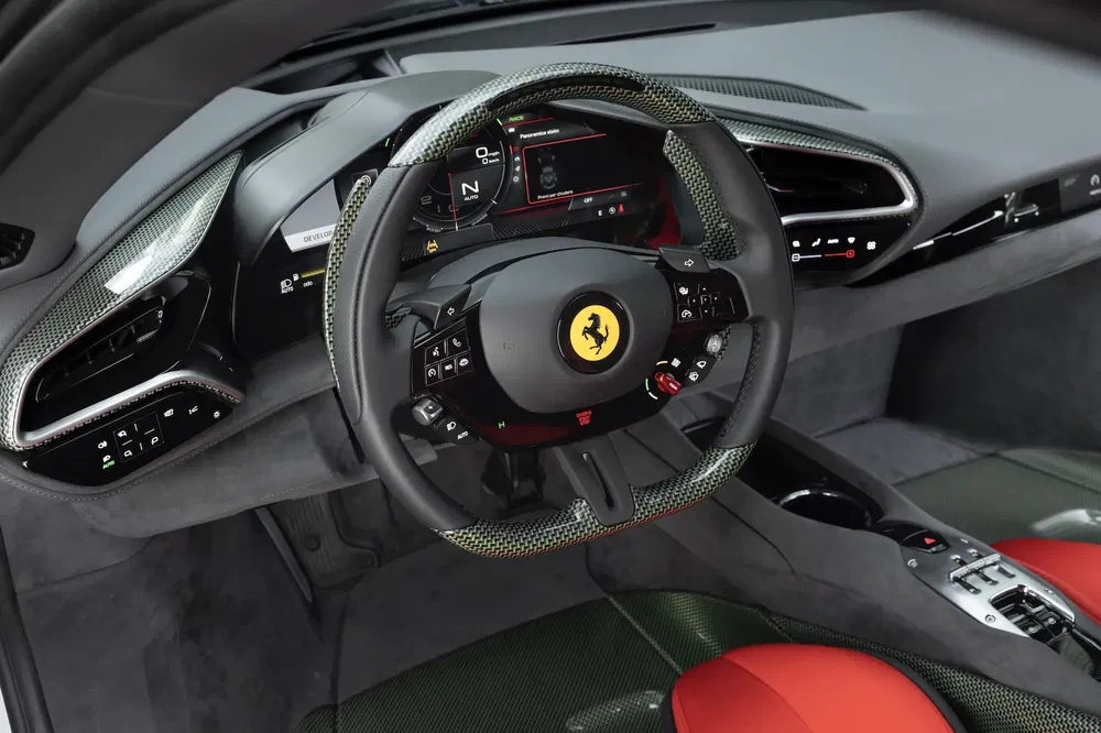 Intérieur d'une Ferrari, volant en fibre de carbone et tableau de bord numérique élégant.
