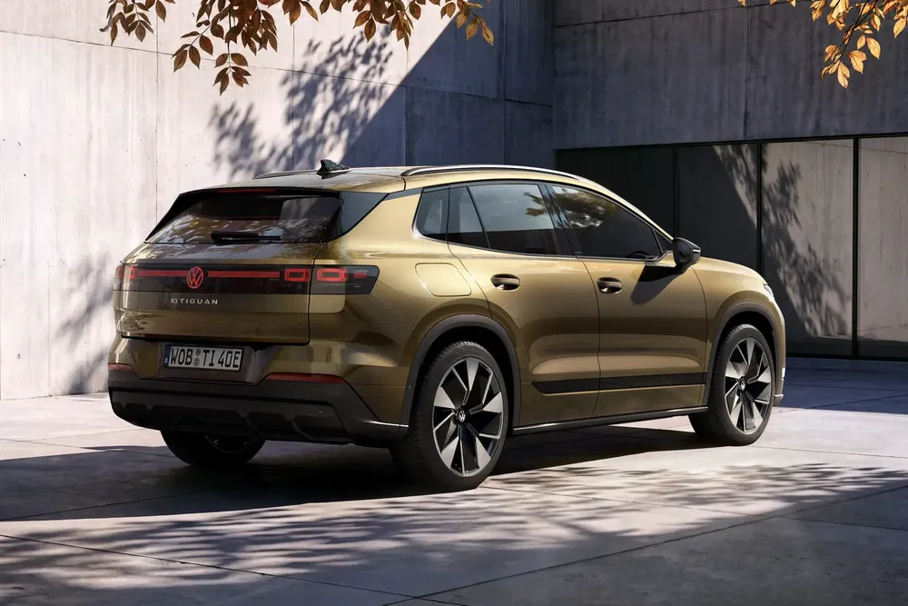 Volkswagen Tiguan doré garé dans une allée moderne, lumière automnale douce.