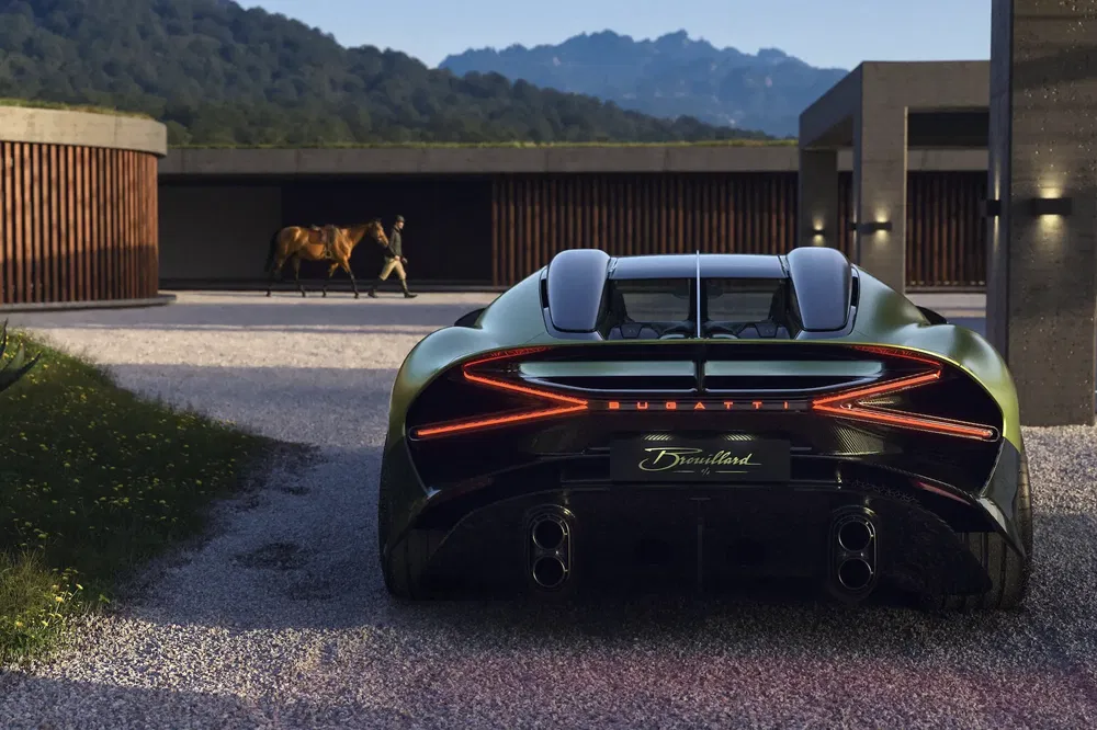 Arrière de la Bugatti, cheval au fond, montagnes et ciel au crépuscule.