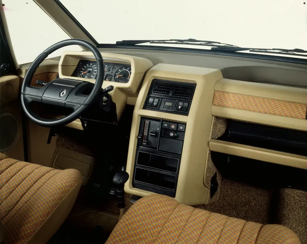 Intérieur de la Renault 5 classique avec sièges et tableau de bord beige vintage.