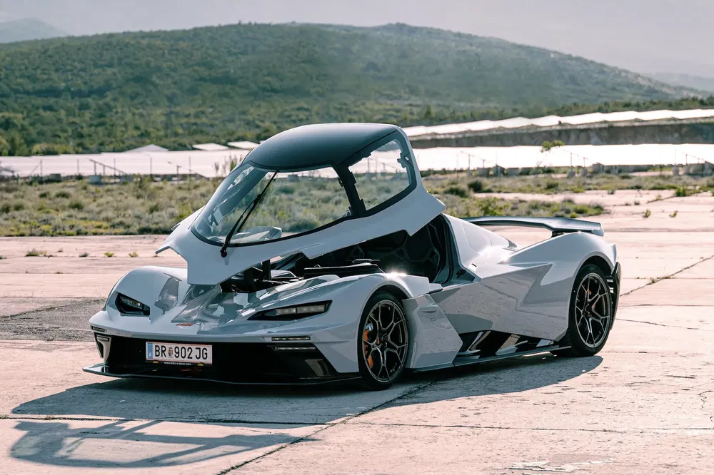 Voiture sportive électrique futuriste sur piste, design unique, paysage montagneux en arrière-plan.