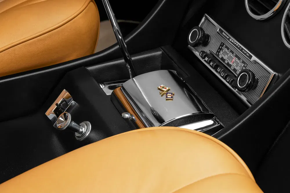 Intérieur d'une voiture vintage avec tableau de bord rétro et sièges cuir tan.