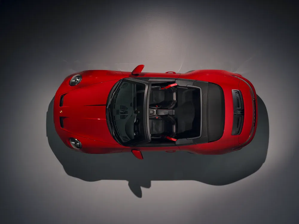 Vue aérienne d'une Porsche 911 rouge décapotable, montrant l'intérieur et les sièges sport.