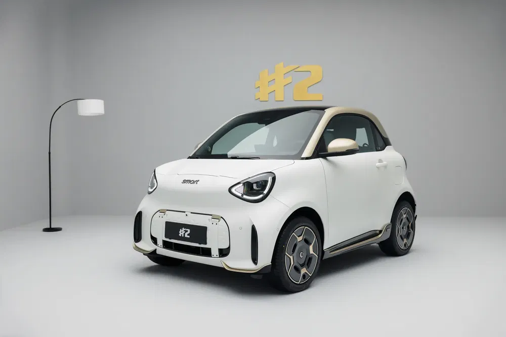 Witte compacte Smart auto met modern ontwerp in een minimalistische studio.