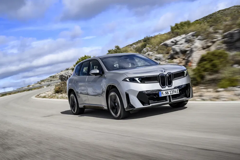 {"fr":"BMW iX argenté en conduite sur route sinueuse, ciel bleu avec nuages en arrière-plan.","nl":"Zilveren BMW iX rijdt op bochtige weg, blauwe lucht met wolken op achtergrond."}