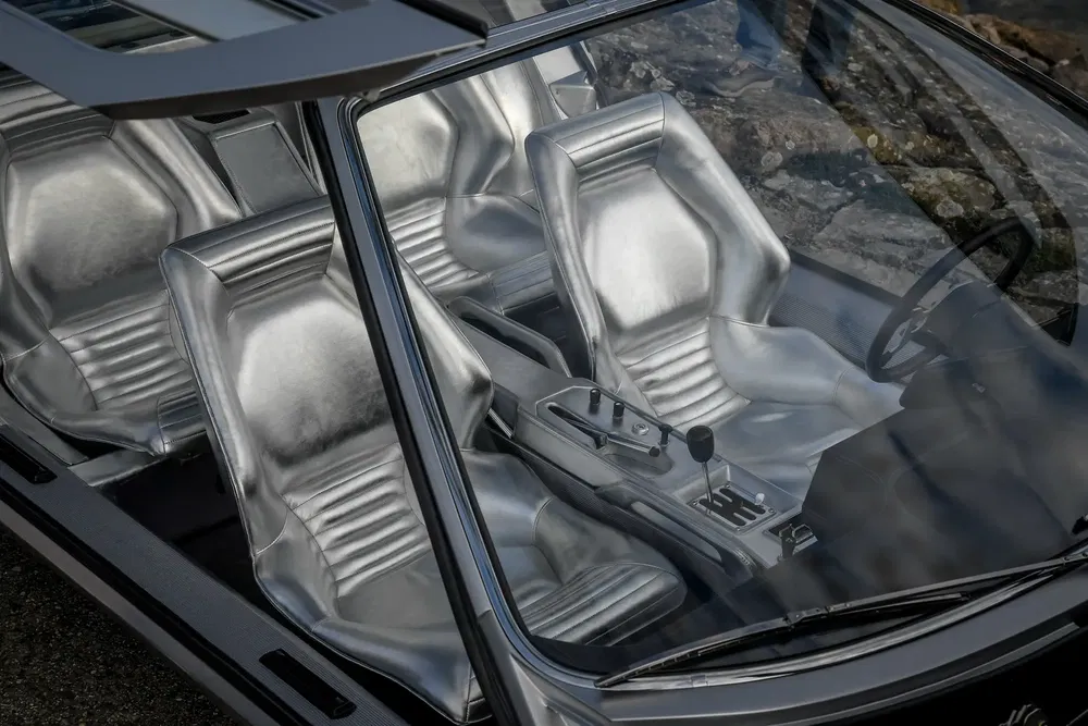 Interieur van DeLorean auto met zilveren lederen stoelen, gezien door het open dak.