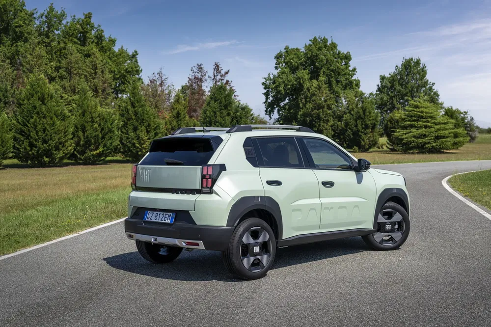 SUV Fiat Panda vert sur une route entourée d'arbres, vue arrière et latérale.