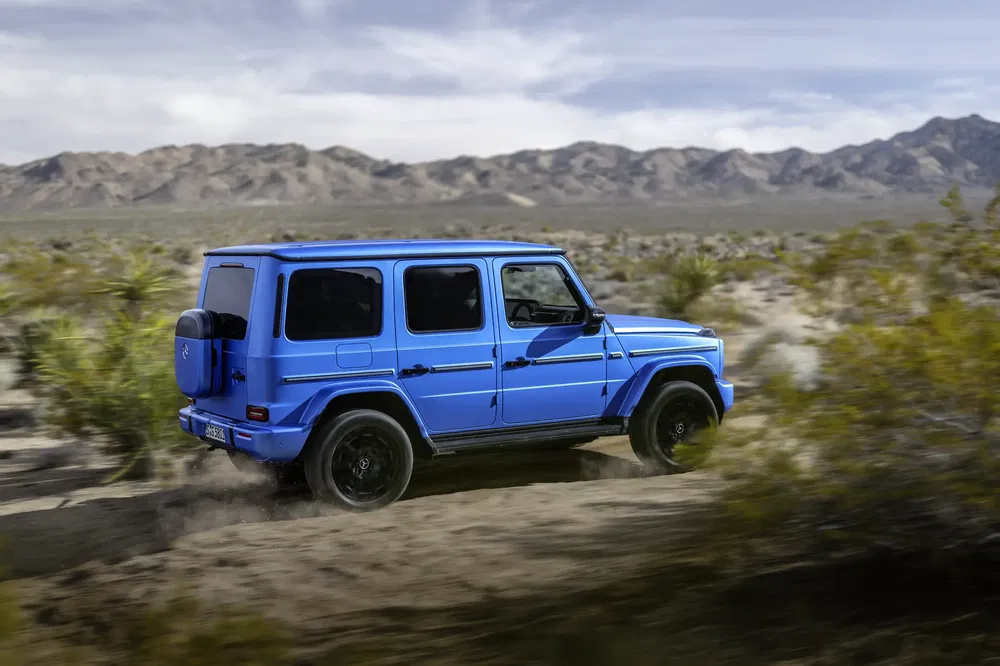 Mercedes-Benz G-Class bleu traversant un désert montagneux en conduite tout-terrain.
