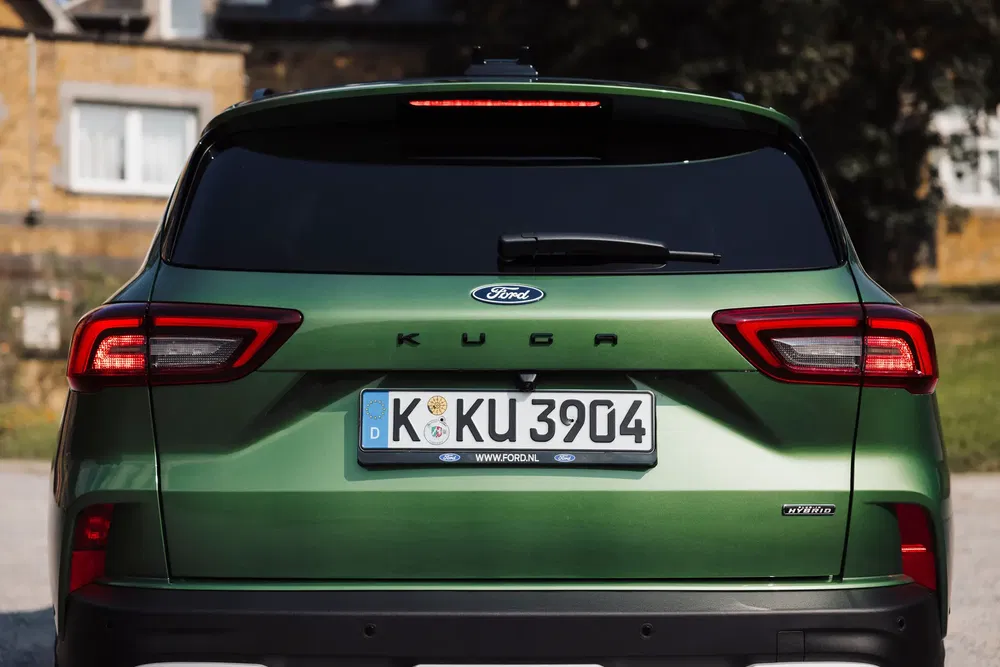 Ford Kuga vert hybride stationné, vue arrière avec plaque d'immatriculation européenne.