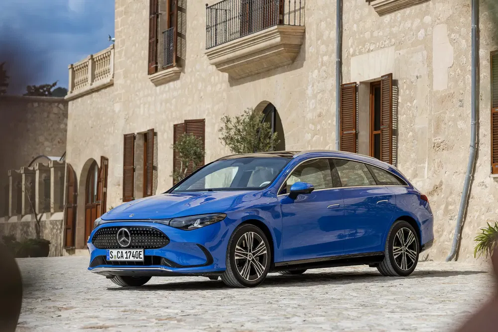 Break Mercedes-Benz bleu devant un bâtiment en pierre, design moderne et élégant.