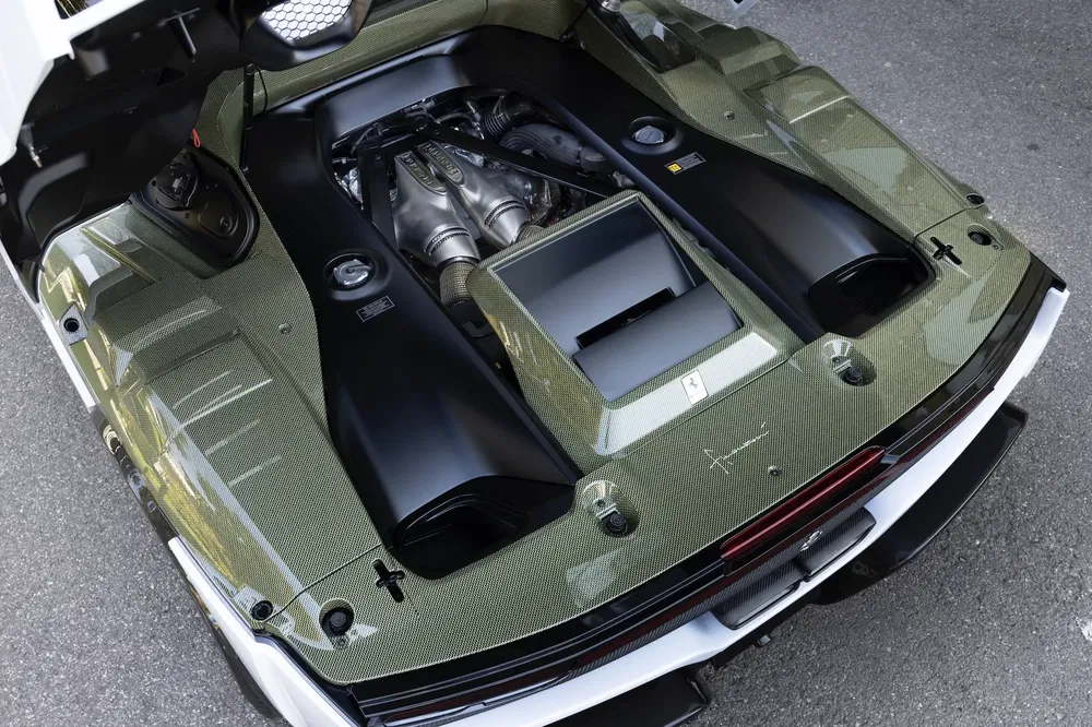 Moteur arrière Ferrari dans un caisson en fibre de carbone, exposant ingénierie et puissance.