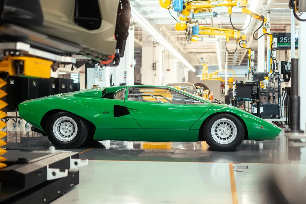 Groene Lamborghini Countach in autofabriek, productieomgeving, industrieel verlichte ruimte.