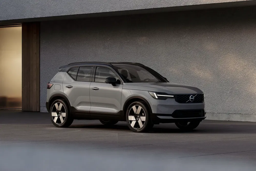 Volvo EX30 SUV gris stationné devant un bâtiment moderne.