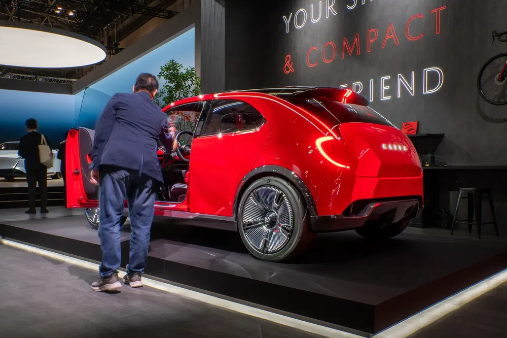 Rode Honda conceptauto op een autosalon met verlicht interieur en modern ontwerp.