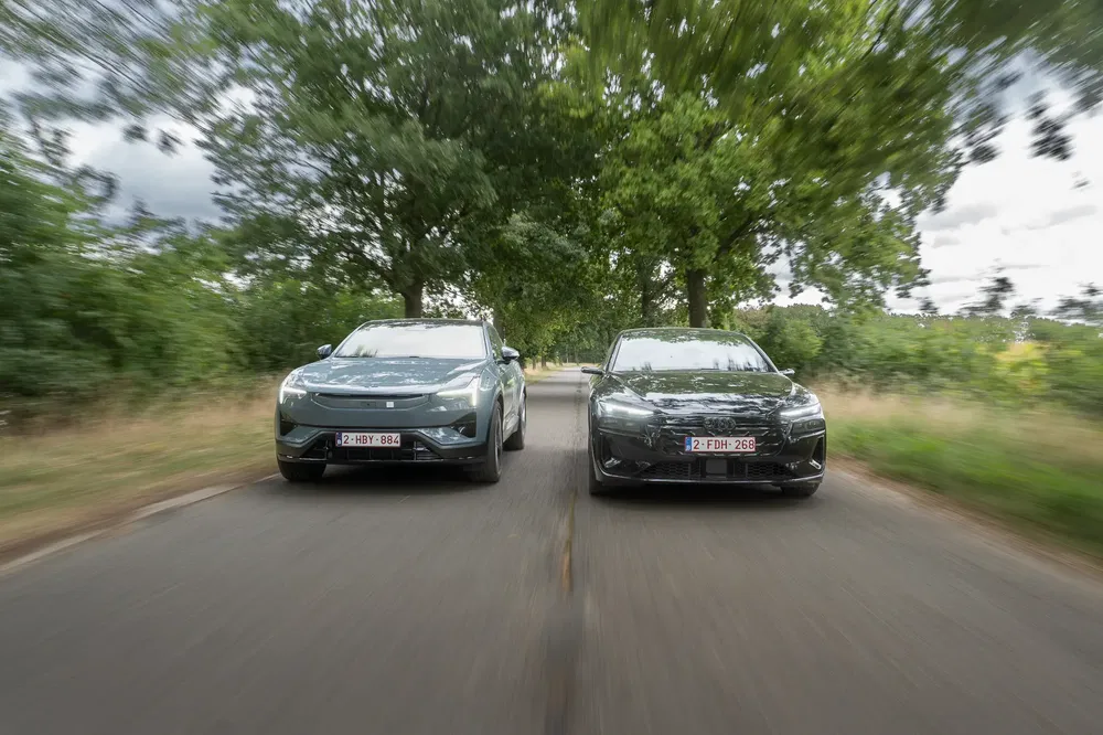 Deux voitures Polestar roulant sur une route bordée d'arbres, en pleine accélération.
