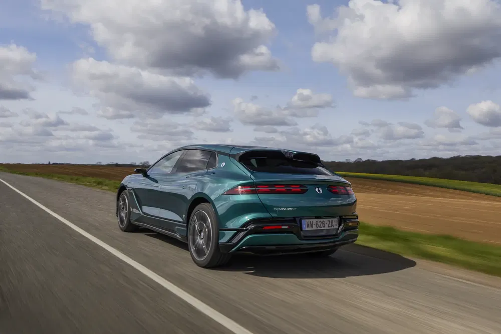 Elektrische auto op landweg met bewolkte lucht, modern en gestroomlijnd ontwerp.