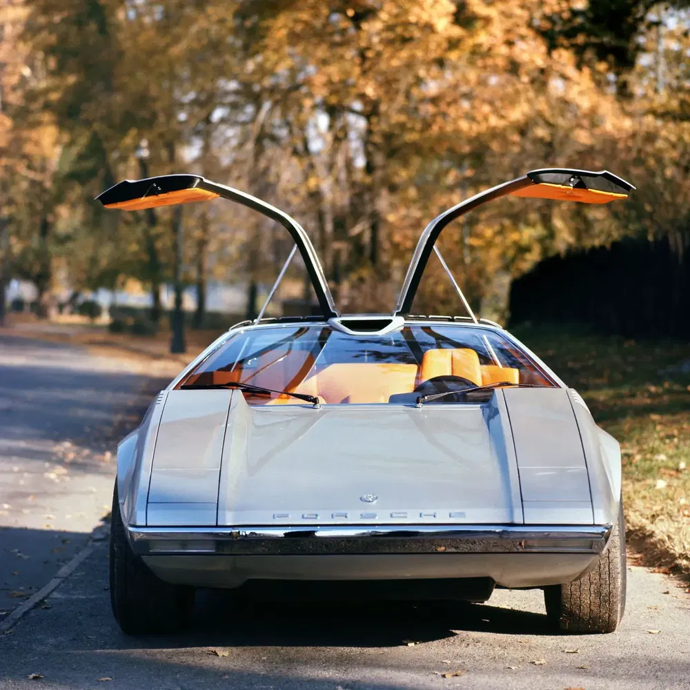 Concept car Porsche futuriste avec portes papillon ouvertes en arrière-plan automnal.
