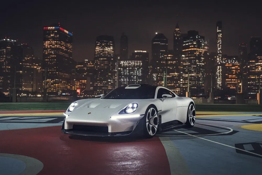 Zilverkleurige Porsche auto geparkeerd voor verlichte stedelijke skyline 's nachts.