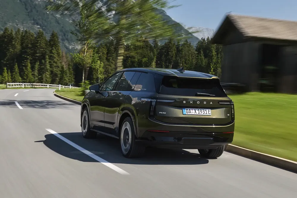{"fr":"Skoda Enyaq noir roulant sur une route montagneuse sinueuse, paysage forestier en arrière-plan.","nl":"Zwarte Skoda Enyaq rijdt op bochtige bergweg, omringd door boslandschap."}