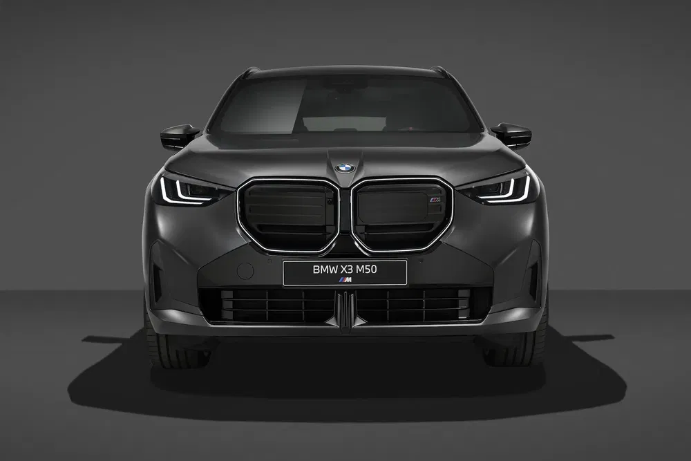 Vue avant de la BMW X3 M50, silhouette sombre et élégante, sur fond neutre.