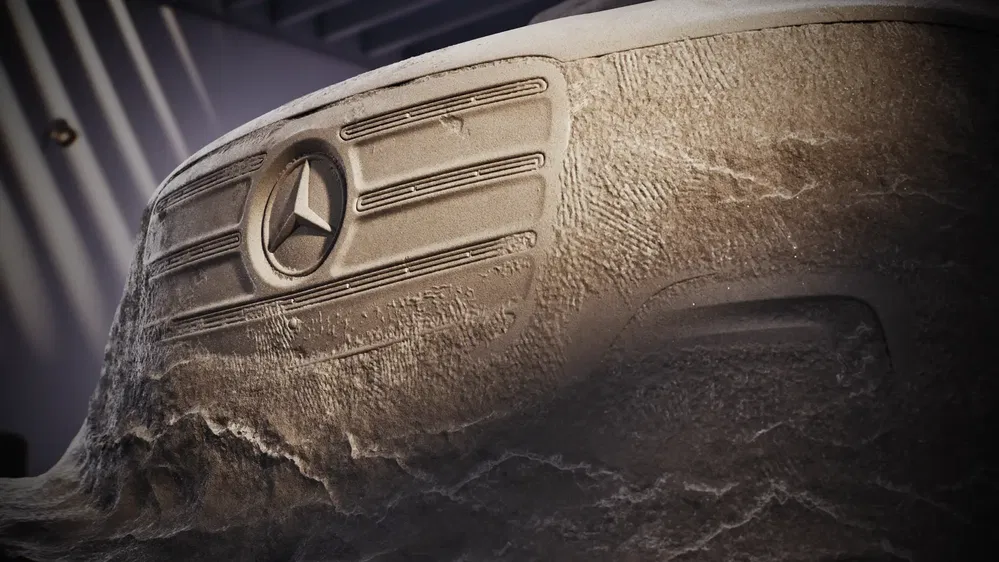 Calandre Mercedes enneigée dans un garage fermé, symbolisant l'hiver et la puissance automobile.
